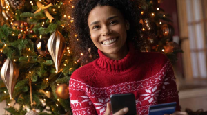 Last minute Christmas shopping woman smiling Christmas phone